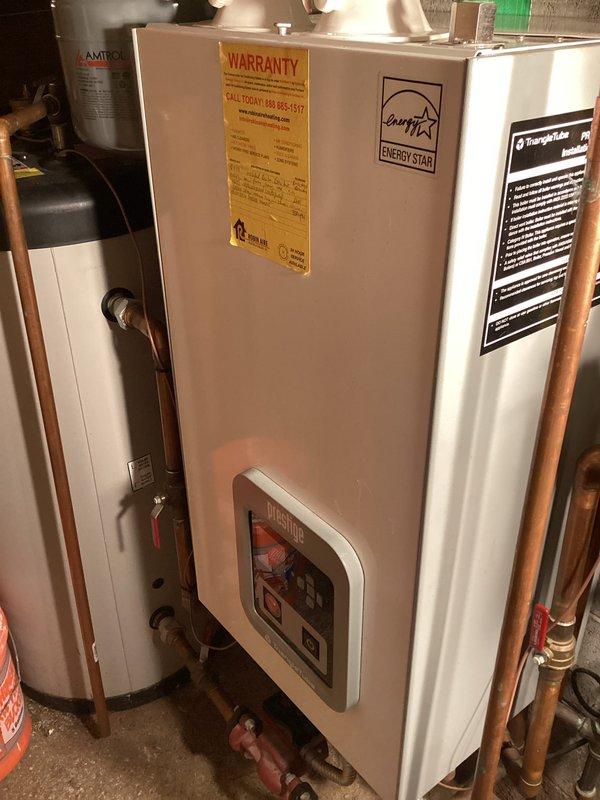 Completed scheduled boiler maintenance service on a tankless water heater system between 5-7pm as requested. Performed comprehensive inspection of all internal components with front panel removed, checking ignition system, control wiring, and plumbing connections. System appears to be functioning properly with no visible leaks or deterioration in the copper piping or Amtrol expansion tank.
