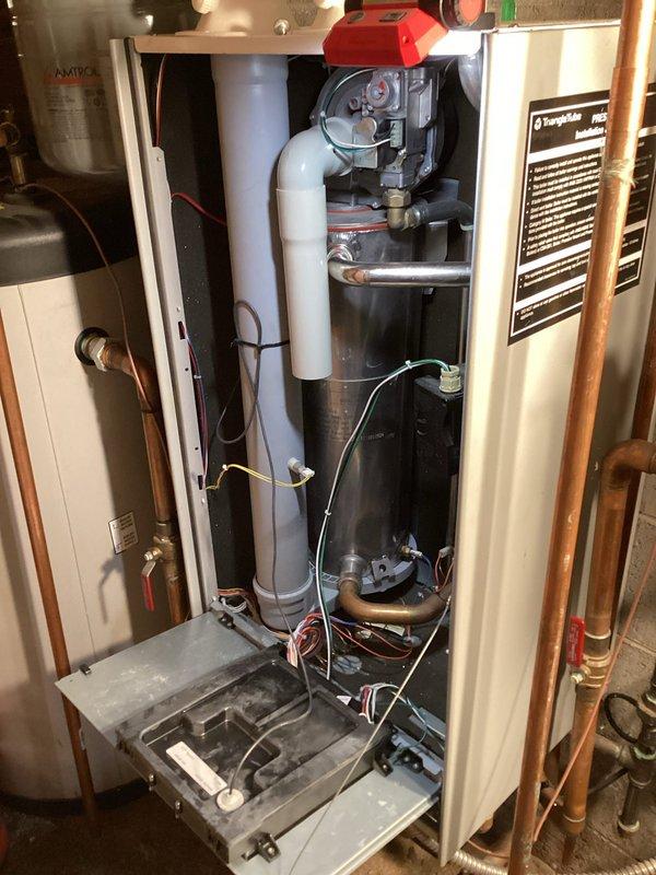 Completed scheduled boiler maintenance service on a tankless water heater system between 5-7pm as requested. Performed comprehensive inspection of all internal components with front panel removed, checking ignition system, control wiring, and plumbing connections. System appears to be functioning properly with no visible leaks or deterioration in the copper piping or Amtrol expansion tank.