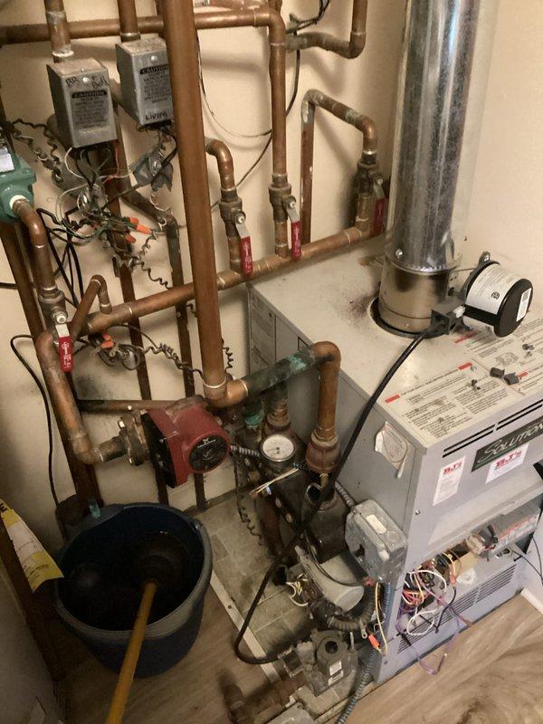 Performed assessment of 26-year-old failed boiler system in residential mechanical room. Documented extensive copper hydronic piping network with multiple valves and aging components showing oxidation. Provided estimate for complete replacement of outdated heating system with new high-efficiency unit.