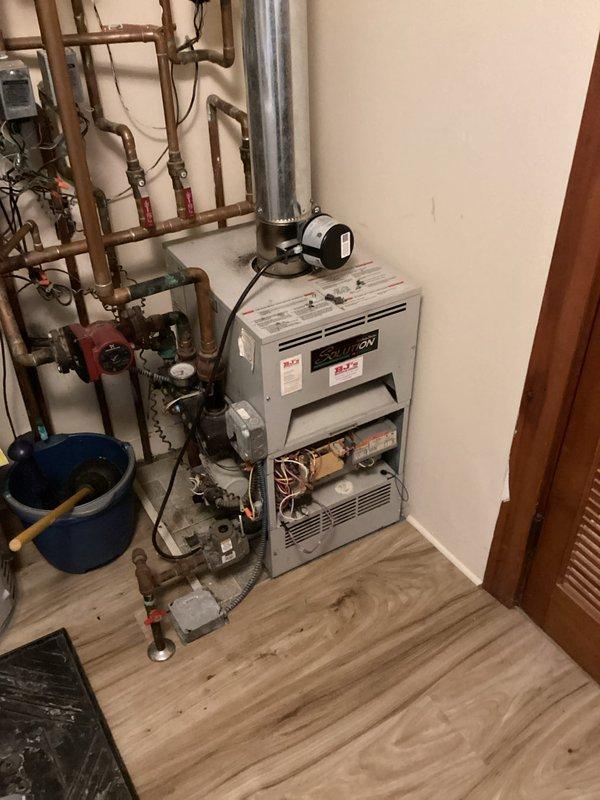 Performed assessment of 26-year-old failed boiler system in residential mechanical room. Documented extensive copper hydronic piping network with multiple valves and aging components showing oxidation. Provided estimate for complete replacement of outdated heating system with new high-efficiency unit.