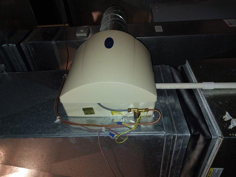 Responded to service call for a 15-year-old furnace producing unusual noise. Conducted comprehensive system inspection, focusing on connection points and humidifier components. Identified and secured loose copper piping connections at brass fitting junction and verified proper operation of the humidifier unit mounted on ductwork, ensuring all electrical connections (red, yellow, blue wiring) were properly secured and functional.