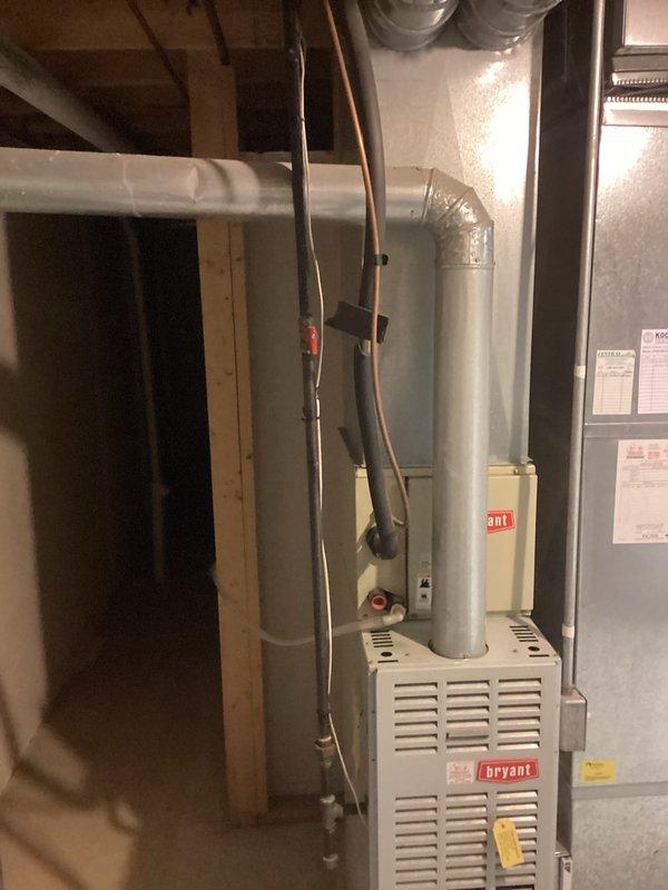 Conducted estimate for replacement of 29-year-old Bryant furnace located in basement. Inspected existing HVAC system including ductwork connections and exhaust flue configuration. Also noted Rheem Performance water heater installation with associated plumbing connections that would need to be considered in the replacement plan. Photos documented current setup for proper sizing and installation requirements of new furnace.