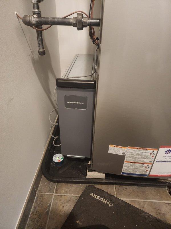 Responded to callback for a Honeywell thermostat installation issue where only 2 of 4 mounting screws were installed, causing instability. Noted customer request to relocate wiring that currently obstructs filter access. Provided estimate for future furnace removal and reinstallation to accommodate planned flooring renovation.