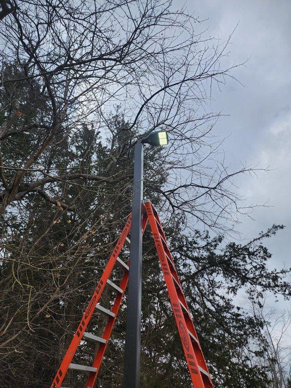 Completed warranty replacement of subdivision lighting fixtures. Utilized extension ladder to access elevated pole-mounted fixtures. Successfully restored outdoor illumination to specified area per warranty requirements.