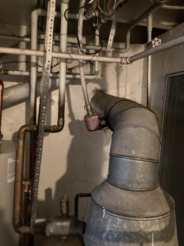 Conducted on-site assessment of Weil-McLain boiler system and Bradford White water heater installation for replacement estimate (CQ Quote: 03852-03 Boiler Est3-4p). Documented existing ductwork condition, noting worn metal ducting with multiple bends and connections, alongside PVC and copper piping configuration. System is installed in basement utility area beneath staircase with expansion tank and associated valves requiring comprehensive replacement solution.