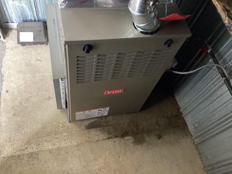 Completed installation of a Bryant furnace in basement utility area, including proper mounting on concrete floor, connection of metal ventilation duct, and installation of filtration system with clear housing. All electrical connections were secured and system was tested for proper operation before completion.