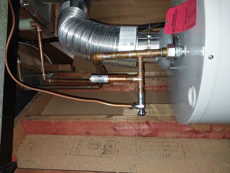 Diagnosed and repaired a leaking whole-house humidifier mounted to the air duct system. Inspected adjacent water heater installation and associated copper plumbing connections to identify the source of the leak. Documented repair with photos of the completed installation showing proper mounting and connections.