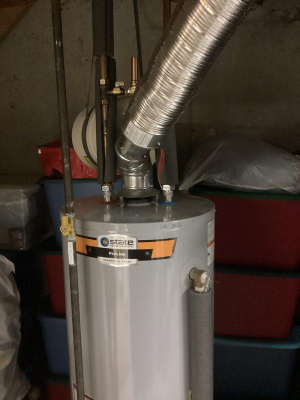 Conducted inspection of State brand water heater exhibiting leakage from tank bottom. Unit shows signs of deterioration with visible water accumulation at base. Documented current installation configuration including gas connections, vent piping, and water supply lines to provide comprehensive replacement estimate as requested.