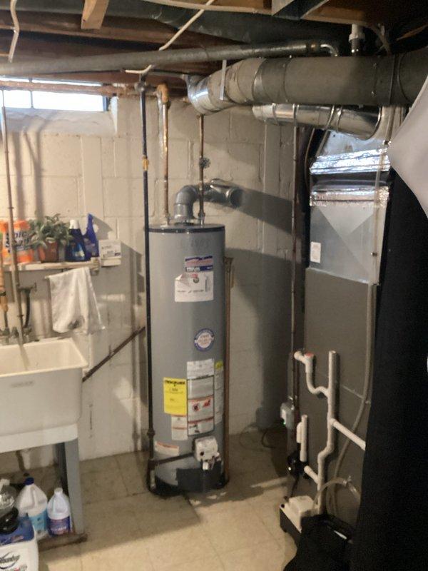 Conducted an inspection of a 10-year-old water heater (2013 model) that was actively leaking from the bottom. Photos documented the American ProLine unit installed in basement utility area, showing visible water leakage at tank base. Recommended replacement due to tank failure and age of equipment.