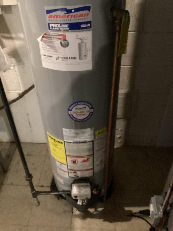 Conducted an inspection of a 10-year-old water heater (2013 model) that was actively leaking from the bottom. Photos documented the American ProLine unit installed in basement utility area, showing visible water leakage at tank base. Recommended replacement due to tank failure and age of equipment.