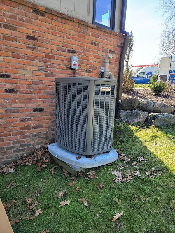 # HVAC Complete System Installation

Successfully completed full HVAC system replacement including installation of new Lennox furnace, Lennox air conditioning condenser unit, S40 smart thermostat, and whole-home humidifier. Removed existing equipment and replaced refrigerant lineset to ensure optimal system performance and efficiency. 

New outdoor condenser unit positioned on concrete pad against building exterior with proper clearances maintained for airflow and serviceability. Electrical disconnect box mounted on exterior wall with appropriate conduit routing. All refrigerant lines, electrical connections, and condensate drainage properly installed per manufacturer specifications and local codes.

Indoor furnace installation completed with integration of humidifier for enhanced comfort control. S40 thermostat installed and programmed, providing advanced climate control features and system monitoring capabilities. All components tested and verified operational. System charged to prop