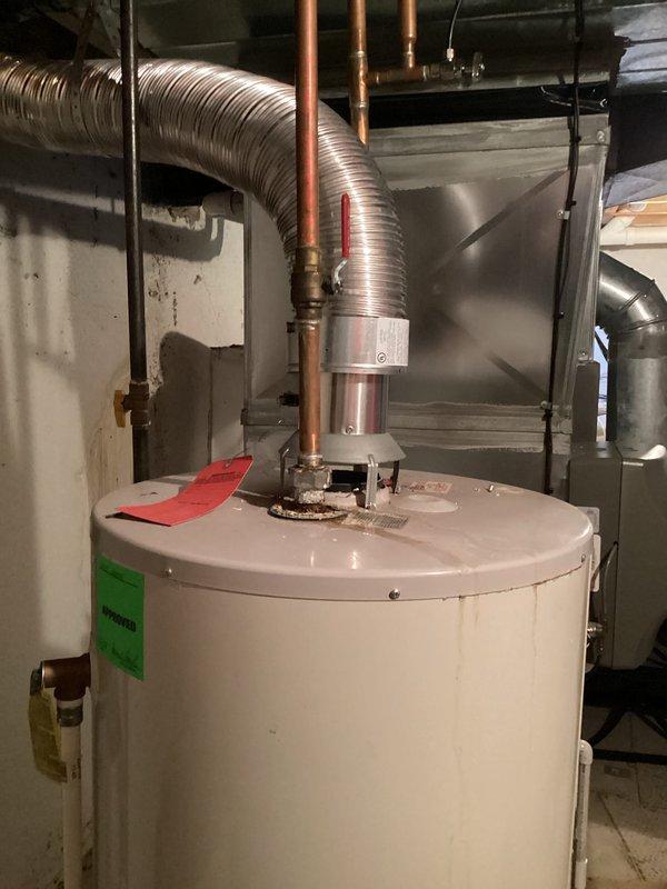 # HVAC Estimate - Replacement Summary

Responded to service call for leaking water heater tank. Upon inspection, confirmed active leak at base of unit with visible mineral deposits and moisture accumulation on concrete floor surrounding tank foundation. Documented existing water heater installation including all plumbing connections, copper supply lines, and venting configuration. Photographed compromised tank showing crystalline buildup indicative of prolonged seepage and tank failure. Prepared comprehensive replacement estimate for new water heater installation to address failed unit and restore domestic hot water service.