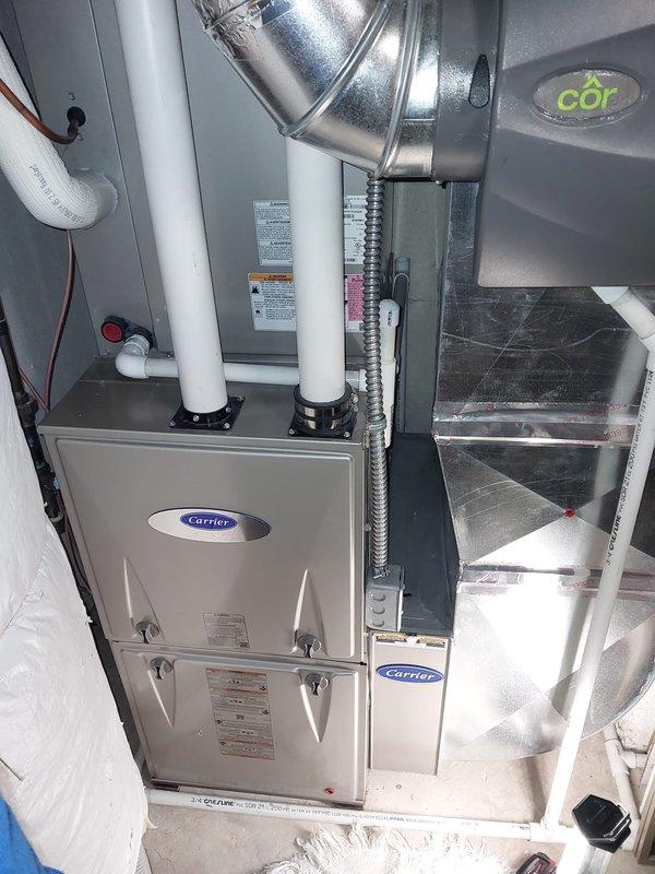 # HVAC Maintenance - Heating System Service Report

## Summary
Completed comprehensive furnace maintenance and safety inspection on Carrier high-efficiency gas furnace unit as part of consumer rebate program, verifying all components operating within manufacturer specifications.

## Work Performed

Conducted thorough preventive maintenance on Carrier brand residential forced-air heating system. Removed front access panel to perform internal inspection of all major components. Verified proper operation of induced draft blower motor assembly and inspected electrical connections throughout the unit.

Utilized digital multimeter with clamp probe to measure electrical current draw on blower motor, confirming amperage readings within acceptable parameters. Tested all safety controls and limit switches for proper operation. Inspected heat exchanger for signs of stress, cracks, or corrosion—no issues detected.

Examined PVC intake and exhaust venting system for proper installation, secure moun