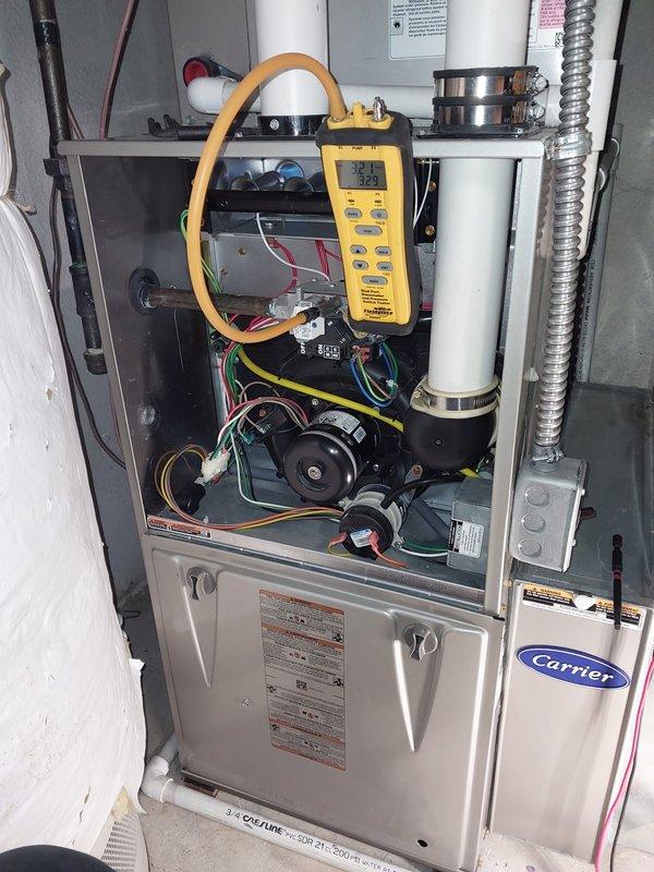 # HVAC Maintenance - Heating System Service Report

## Summary
Completed comprehensive furnace maintenance and safety inspection on Carrier high-efficiency gas furnace unit as part of consumer rebate program, verifying all components operating within manufacturer specifications.

## Work Performed

Conducted thorough preventive maintenance on Carrier brand residential forced-air heating system. Removed front access panel to perform internal inspection of all major components. Verified proper operation of induced draft blower motor assembly and inspected electrical connections throughout the unit.

Utilized digital multimeter with clamp probe to measure electrical current draw on blower motor, confirming amperage readings within acceptable parameters. Tested all safety controls and limit switches for proper operation. Inspected heat exchanger for signs of stress, cracks, or corrosion—no issues detected.

Examined PVC intake and exhaust venting system for proper installation, secure moun