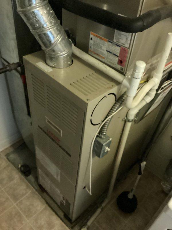 Completed comprehensive HVAC system replacement estimate for aging residential equipment (9-11 years old). Assessed existing furnace, air handler, and associated ductwork configuration in utility space, documenting current installation including metallic flexible duct connections, PVC condensate drainage lines, refrigerant line routing with insulation, and existing duct distribution system with branching configuration and pressure regulation components.