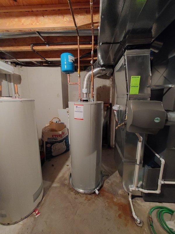 Successfully installed a new 50-gallon residential tanked water heater in the basement mechanical room. The installation included proper connection of hot and cold water supply lines using copper piping, installation and mounting of a blue expansion tank suspended from ceiling joists to protect against thermal expansion, and integration with existing plumbing infrastructure. All connections were secured according to manufacturer specifications and local plumbing codes, with the unit properly positioned on the concrete floor for optimal access and maintenance. The installation ensures reliable domestic hot water supply for the residence.