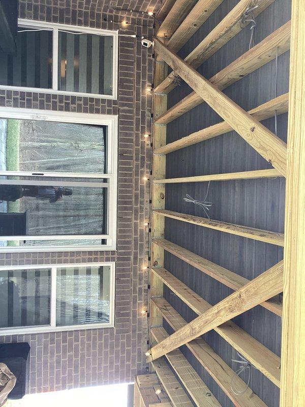 Installed UF cable on underside of deck to supply four new light locations and one new fan location, with power sourced from existing switched light fixture. Ran wiring up wall in protective conduit from tap point to deck underside. Additionally installed UF cable for new receptacle location to control shade screens, tapping power from existing outlet and routing through wall-mounted conduit for protection. All wiring terminated at designated locations for fixture and device installation by under-deck system contractor.