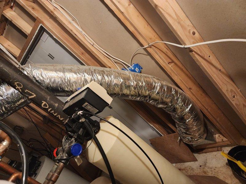 Responded to callback for failed inspection correction related to compressed canvas connector on return duct system. Inspected and photographed attic installation showing flexible ductwork routing, documented existing condition of canvas connector requiring correction per inspection notes. Evaluated basement airflow distribution through registers and confirmed temperature differential of approximately 10 degrees between basement and upper living areas, consistent with previous system performance indicating potential airflow restriction or inadequate duct sizing to lower level zones.