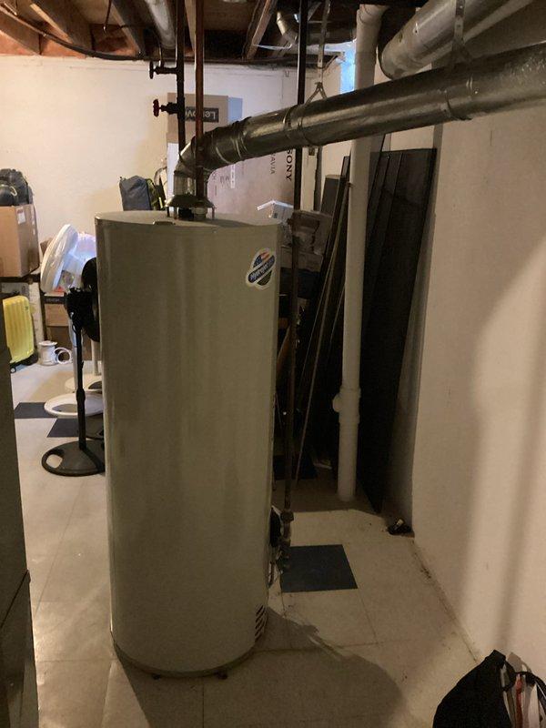 Conducted on-site assessment for water heater replacement in basement utility area. Evaluated existing water heater installation, surrounding infrastructure including overhead ductwork, PVC piping configuration, and electrical connections. Documented current equipment condition and spatial requirements for replacement unit, photographed installation area to provide comprehensive estimate for water heater upgrade.