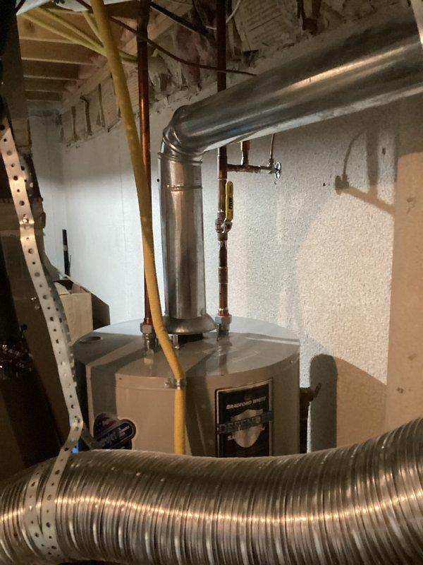 Completed estimate for water heater replacement due to active leak. Documented existing installation including gas line connections, copper water piping with shutoff valves, and venting configuration with metallic ductwork in basement utility space.