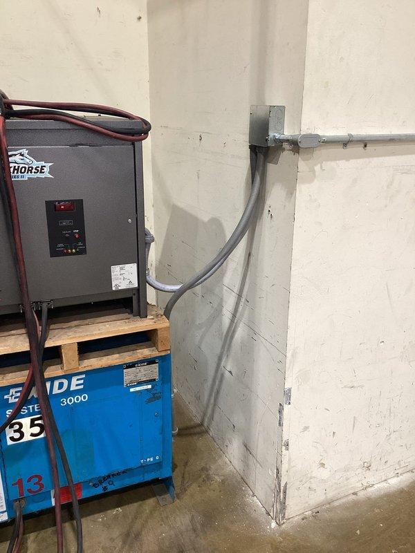 Disconnected two Hi-Lo battery chargers at their original location to facilitate relocation by the customer. Installed one 50-amp three-phase 208-volt breaker and dedicated circuit, along with one 30-amp three-phase 208-volt breaker and dedicated circuit at the new business location. Terminated both Hi-Lo chargers to the new circuits, positioning the equipment to the left of the electrical service in the corner adjacent to the service transformer, with all conduit runs properly secured and connections verified operational.