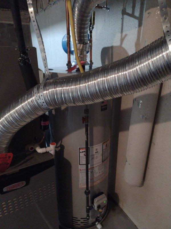 Completed installation of residential tanked water heater in basement utility area. Unit was positioned against wall with proper clearances maintained from HVAC equipment and ductwork, with all supply and discharge plumbing connections secured and tested for leaks. Installation meets code requirements for mechanical room placement and venting specifications.