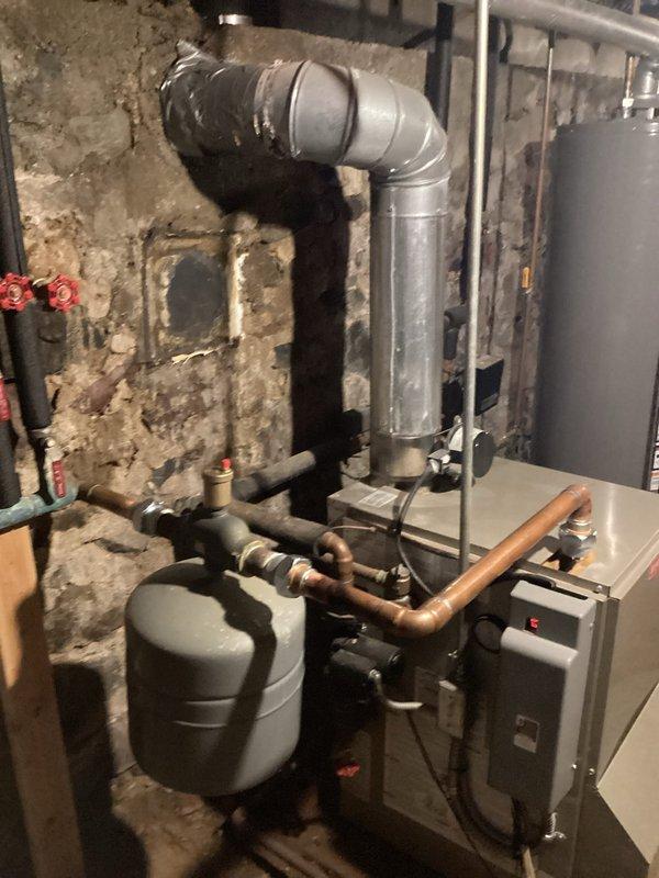Responded to no-heat call for 8-year-old Bryant boiler system experiencing water leak and electrical short in basement mechanical room. Upon arrival, identified active water leak affecting electrical components, creating safety hazard and preventing system operation. Shut down power to boiler and isolated water supply to prevent further damage. Traced leak source to compromised piping connection near expansion tank assembly. Dried electrical components and inspected control board and wiring for water damage. Repaired leaking pipe connection and pressure-tested system to verify seal integrity. Restored power after confirming all electrical components were dry and safe. Cycled boiler through startup sequence and verified proper ignition, flame operation, and heat distribution. Monitored system for 20 minutes to ensure no recurrence of leak and confirmed stable operation. System restored to full heating capacity with no further issues detected.
