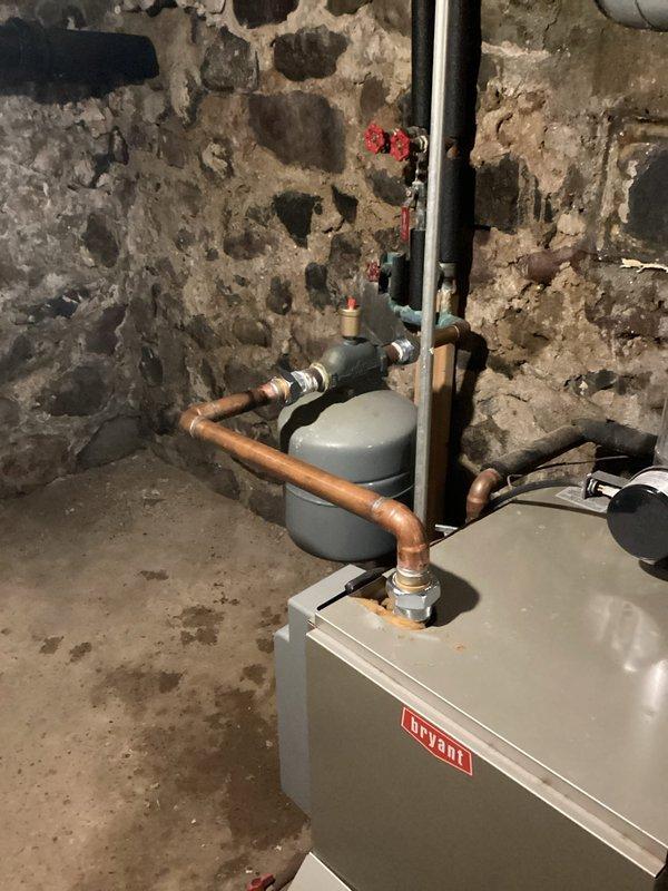 Responded to no-heat call for 8-year-old Bryant boiler system experiencing water leak and electrical short in basement mechanical room. Upon arrival, identified active water leak affecting electrical components, creating safety hazard and preventing system operation. Shut down power to boiler and isolated water supply to prevent further damage. Traced leak source to compromised piping connection near expansion tank assembly. Dried electrical components and inspected control board and wiring for water damage. Repaired leaking pipe connection and pressure-tested system to verify seal integrity. Restored power after confirming all electrical components were dry and safe. Cycled boiler through startup sequence and verified proper ignition, flame operation, and heat distribution. Monitored system for 20 minutes to ensure no recurrence of leak and confirmed stable operation. System restored to full heating capacity with no further issues detected.