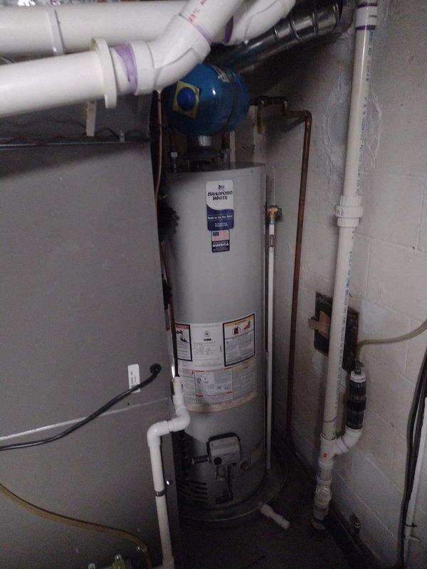 Completed full HVAC system installation including Lennox furnace with properly vented white PVC exhaust piping, heat pump system, 40-gallon residential water heater with expansion tank, and S40 programmable thermostat. Relocated air conditioning condenser unit from front to rear of property, requiring refrigerant line relocation and electrical circuit extension. All equipment installed to manufacturer specifications with proper venting, drainage, and electrical connections verified operational.