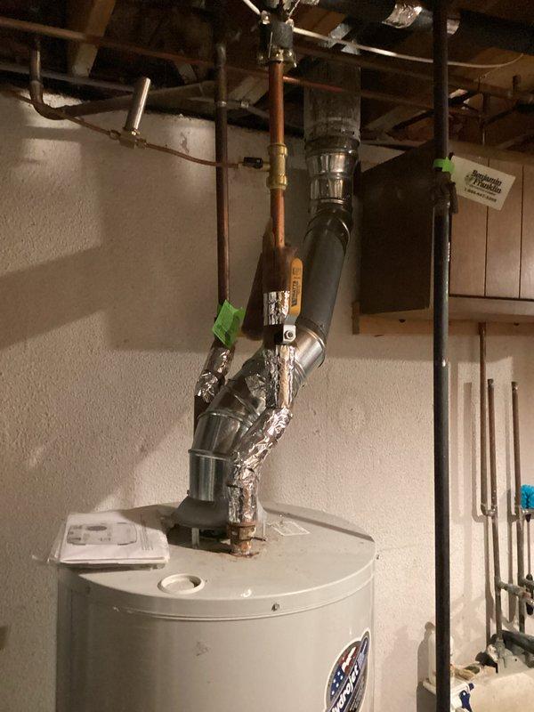 Responded to service call for a leaking gas water heater producing rusty water in a 45-year-old residential property. Upon inspection, confirmed the 7.5-year-old unit was actively leaking and showing signs of internal tank corrosion, as evidenced by rust contamination in the hot water supply. Documented existing installation configuration including copper supply lines, gas connections, metallic vent piping, and proximity to HVAC equipment in the basement mechanical room. Photographed the current water heater setup, plumbing connections with shut-off valves, exhaust venting system, and surrounding utility area layout. Provided comprehensive replacement estimate to customer for new gas water heater installation.
