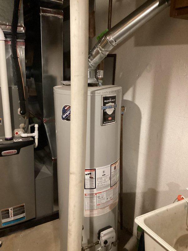 Responded to service call for a leaking gas water heater producing rusty water in a 45-year-old residential property. Upon inspection, confirmed the 7.5-year-old unit was actively leaking and showing signs of internal tank corrosion, as evidenced by rust contamination in the hot water supply. Documented existing installation configuration including copper supply lines, gas connections, metallic vent piping, and proximity to HVAC equipment in the basement mechanical room. Photographed the current water heater setup, plumbing connections with shut-off valves, exhaust venting system, and surrounding utility area layout. Provided comprehensive replacement estimate to customer for new gas water heater installation.