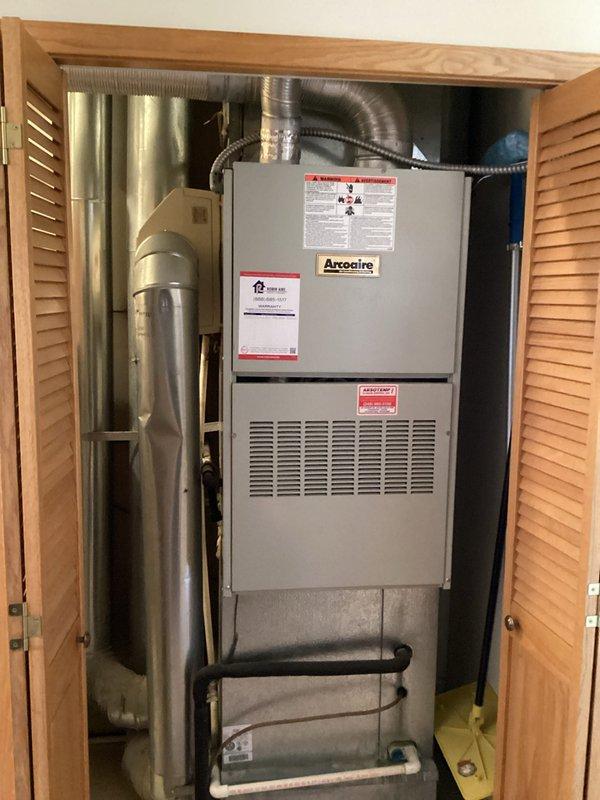 Conducted on-site evaluation of 28-year-old Arcoaire furnace system located in utility closet for replacement estimate. Documented existing equipment configuration including furnace unit, associated ductwork, gas piping, and water lines. Assessed installation space constraints within closet area with louvered door access and evaluated existing ventilation, exhaust routing, and utility connections to determine specifications for new furnace system installation.