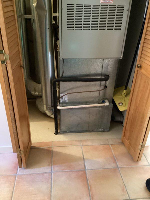 Conducted on-site evaluation of 28-year-old Arcoaire furnace system located in utility closet for replacement estimate. Documented existing equipment configuration including furnace unit, associated ductwork, gas piping, and water lines. Assessed installation space constraints within closet area with louvered door access and evaluated existing ventilation, exhaust routing, and utility connections to determine specifications for new furnace system installation.