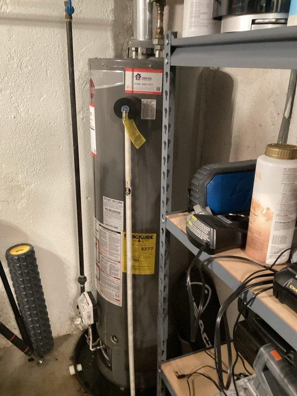 Responded to service call for leaking water heater. Upon inspection, found residential gas-fired water heater showing signs of age with visible corrosion and active leak requiring replacement. Documented existing installation including ductwork configuration in ceiling space and current water heater setup with gas line, plumbing connections, and venting system. Provided estimate for complete water heater replacement.