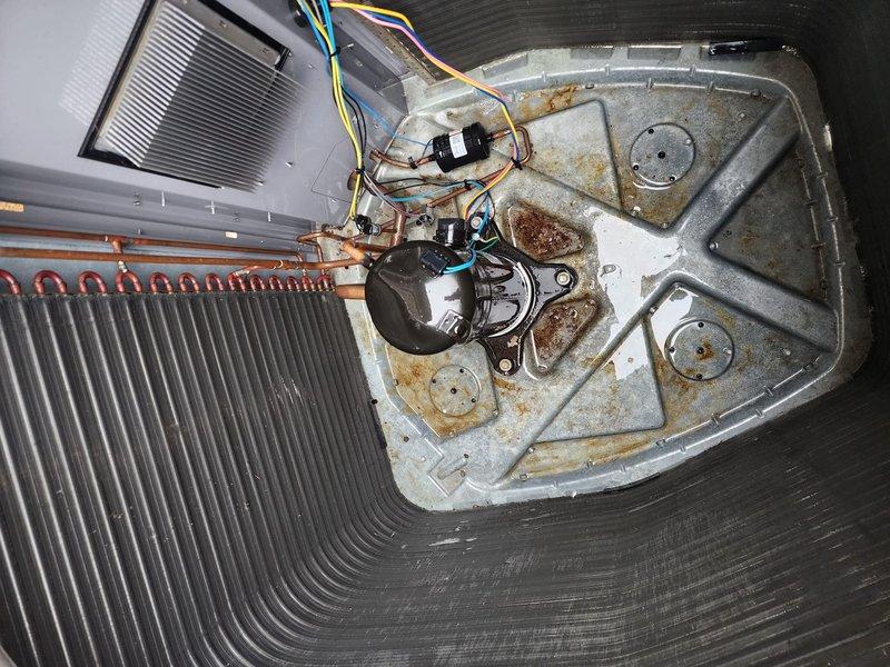 Completed routine cooling system tune-up and maintenance on residential HVAC system. Inspected indoor air handler components including condensate drain pan, condensate pump, refrigerant lines, and filter assembly; noted significant soiling and rust staining in drain pan indicating need for future cleaning attention. Serviced outdoor condenser unit, verified proper operation of compressor and fan motor, confirmed system cooling functionality and left unit in working condition.