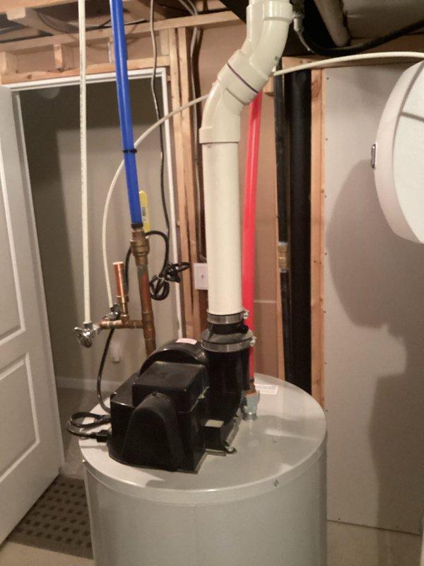 Completed estimate for water heater replacement in residential basement utility area. Assessed existing water heater installation including associated plumbing connections, PEX water lines, copper piping with brass fittings and shut-off valves, PVC drainage system, and circulator pump assembly mounted on current unit. Documented all mechanical components, pipe configurations, and spatial requirements for replacement equipment recommendation.