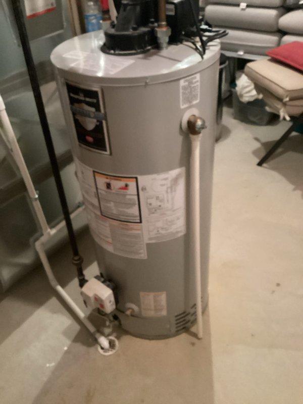 Completed estimate for water heater replacement in residential basement utility area. Assessed existing water heater installation including associated plumbing connections, PEX water lines, copper piping with brass fittings and shut-off valves, PVC drainage system, and circulator pump assembly mounted on current unit. Documented all mechanical components, pipe configurations, and spatial requirements for replacement equipment recommendation.