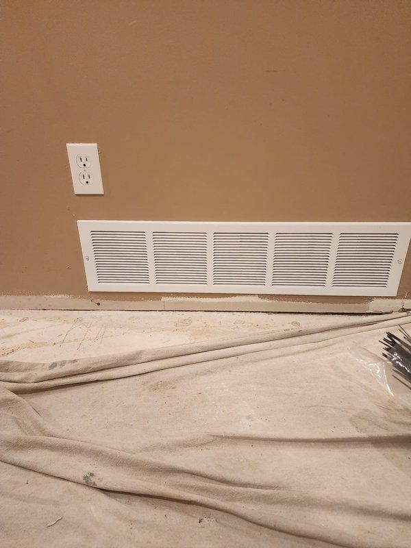 Installed new return air vent in basement utility area to improve HVAC system airflow and circulation. Ran ductwork through existing mechanical room, integrated with current duct system, and mounted white return grille near baseboard on finished wall. Installation completed successfully with all components properly secured and operational.