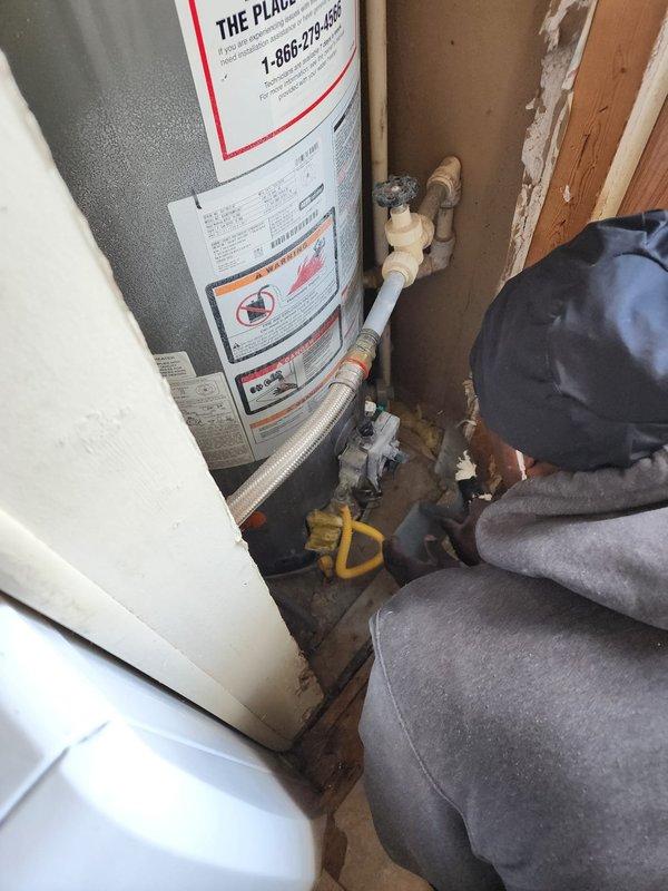 Completed full furnace installation in mobile home residential utility space. New white HVAC furnace unit installed in closet area with proper venting and clearances, secured within existing wood-framed opening adjacent to water heater. All plumbing connections, gas lines, and electrical hookups completed to manufacturer specifications and local code requirements.