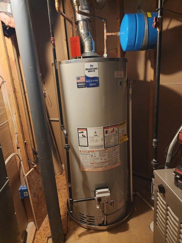 Successfully installed a new 75-gallon Bradford White natural gas water heater (model BG275R6N) in residential utility space. Installation included proper connection of copper supply lines, pressure relief valve, expansion tank mounting, and code-compliant venting with flexible metallic ductwork. All safety labels verified in place, gas connections tested for leaks, and unit confirmed operational upon completion.