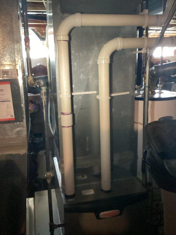 Conducted comprehensive assessment of residential HVAC system for replacement estimate. Evaluated 1997 outdoor condensing unit positioned on concrete pad adjacent to building exterior, noting system age and refrigerant depletion. Documented existing indoor air handler installation in basement mechanical room, including current PVC condensate drainage configuration and equipment mounting. Provided detailed replacement recommendations for complete system upgrade due to equipment age and refrigerant loss.