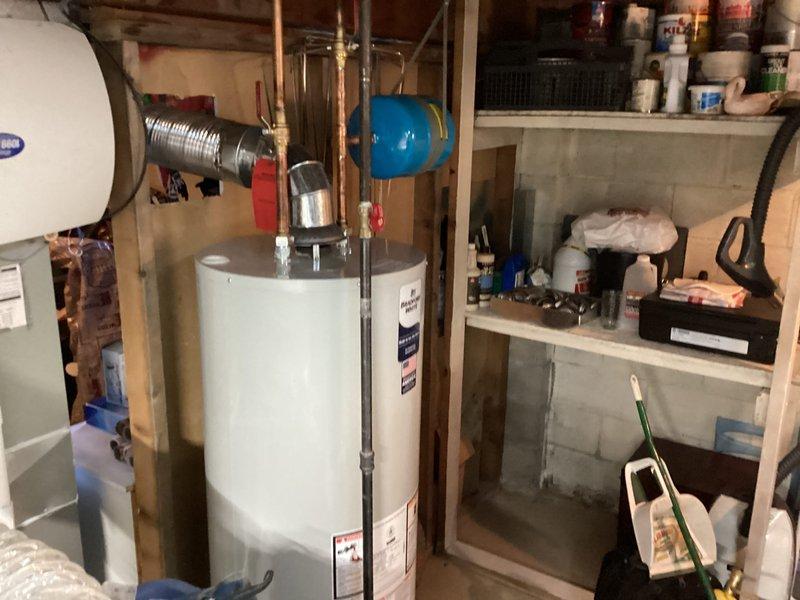 Completed installation of a 40-gallon Bradford White tanked water heater in basement utility area. Connected all necessary copper supply and discharge piping, installed thermal expansion tank, and verified proper operation of temperature and pressure relief valve. System tested and confirmed operational with all connections secure and no leaks detected.
