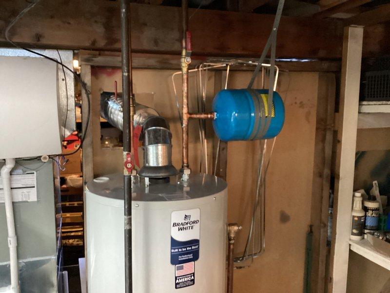 Completed installation of a 40-gallon Bradford White tanked water heater in basement utility area. Connected all necessary copper supply and discharge piping, installed thermal expansion tank, and verified proper operation of temperature and pressure relief valve. System tested and confirmed operational with all connections secure and no leaks detected.