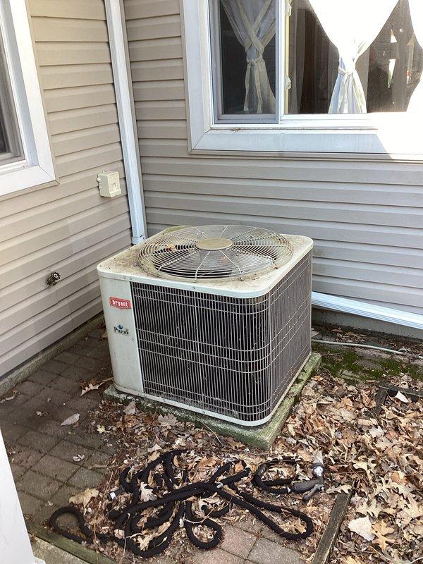 Conducted comprehensive assessment of existing 22-year-old HVAC system for replacement estimate. Inspected indoor furnace unit located in utility room accessible via side door, documenting current installation configuration including metal ductwork, exhaust piping, and ventilation components. Evaluated outdoor Bryant brand condenser unit positioned on concrete pad against exterior wall, noting weathered condition consistent with age and extended service life. Photographed both indoor and outdoor equipment to document existing system layout, accessibility constraints in compact utility space, and current operational setup. Provided detailed replacement estimate based on site conditions and equipment specifications.