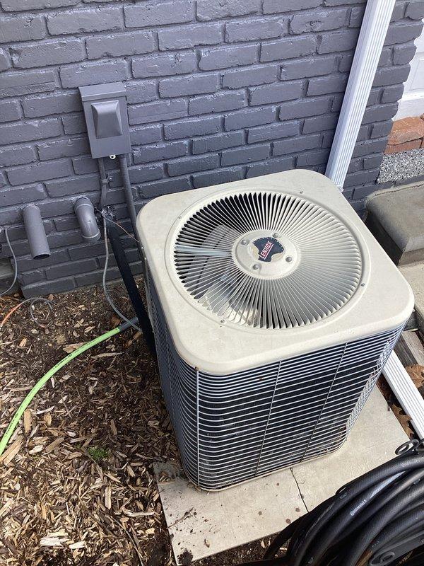 Provided comprehensive replacement estimate for aging residential HVAC system with outdoor R-22 condenser unit dating from 1996 that was found to be low on refrigerant. Assessment included evaluation of both the exterior condensing unit with deteriorating heat exchanger coils and the interior furnace installation, documenting current system condition through detailed photography to support recommendations for complete system replacement due to obsolete refrigerant type and equipment age exceeding typical service life.