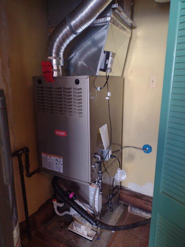 Completed full HVAC system installation including Bryant 80% efficiency gas furnace in interior utility closet and matching outdoor air conditioning condenser unit. Installed furnace with proper venting through flexible aluminum ductwork, connected gas and water lines, completed all electrical wiring and control connections, and mounted necessary safety components including electrical disconnect box. Positioned outdoor condenser on concrete pad against exterior wall with protective grille guard, verified refrigerant lines are properly connected between indoor and outdoor units, and confirmed all electrical connections are secure. System tested and operational upon completion.