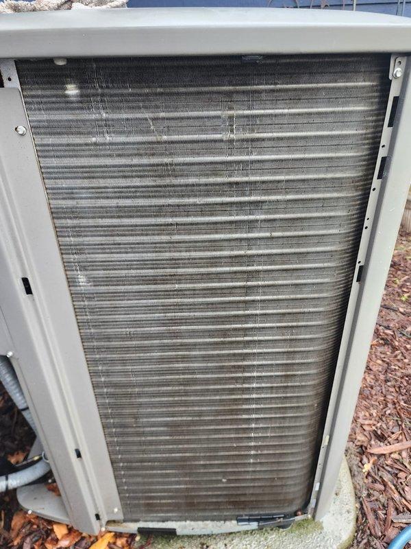 Completed preventive maintenance on residential cooling system. Inspected outdoor condenser unit and observed debris accumulation on heat exchanger coil fins requiring cleaning attention. Examined indoor compressor assembly, refrigerant lines, and electrical connections, confirming all components operational and properly secured within ductwork housing.