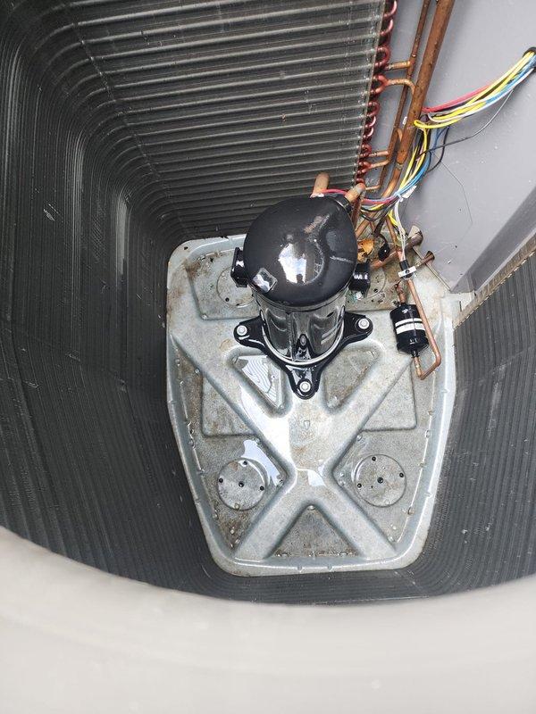 Completed preventive maintenance on residential cooling system. Inspected outdoor condenser unit and observed debris accumulation on heat exchanger coil fins requiring cleaning attention. Examined indoor compressor assembly, refrigerant lines, and electrical connections, confirming all components operational and properly secured within ductwork housing.