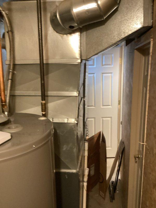 Conducted comprehensive assessment of existing 25-year-old residential air conditioning system for equipment replacement. Evaluated outdoor condenser unit positioned against brick exterior with existing refrigerant lines and condensate drainage system. Inspected indoor air handler and associated ductwork in basement utility area, including connections to water heater and gas lines. Provided detailed replacement estimate for complete AC system upgrade to address aging equipment and ensure optimal cooling performance.