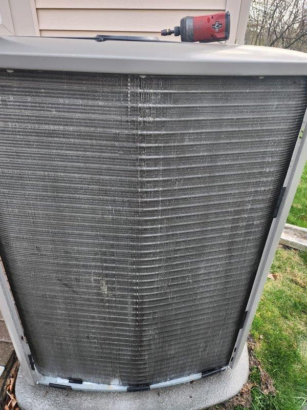 # HVAC Maintenance - Cooling System Service

Completed scheduled air conditioning maintenance on residential cooling system during evening appointment window. Performed comprehensive inspection of outdoor condenser unit, which showed significant accumulation of dirt and debris on heat exchanger coil fins with visible darkening and dust buildup affecting airflow efficiency. Condenser cabinet and frame were in serviceable condition with normal weathering for outdoor exposure.

Accessed indoor air handler unit and inspected evaporator coil section and drain pan assembly. Found condensate drain pan with moderate mineral deposits and water staining around drain fitting, indicating active moisture management but requiring attention to prevent future blockages. Drain line and condensate removal system were operational with proper drainage observed. Inspected electrical connections and refrigerant line connections at air handler, which appeared secure with appropriate insulation intact.

Syste